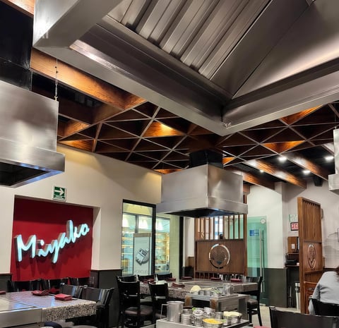 Modern warehouse loft interior with red Mojo neon sign, exposed beam ceiling, and contemporary furniture display